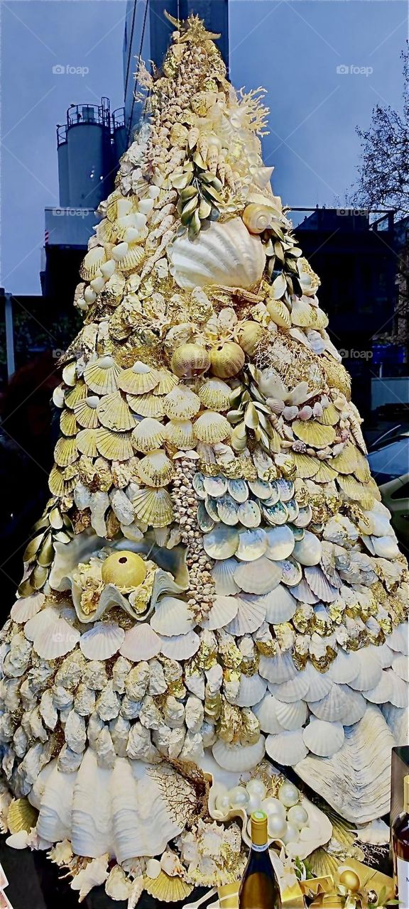 A large artistic Christmas tree is on display in “München”, capital of “Bavaria” on the “Odeonsplatz” featuring guilded seashells, flowers, berries, even vegetables. This much originality does bring out the holiday spirit. 2023. Hypnotic Productions