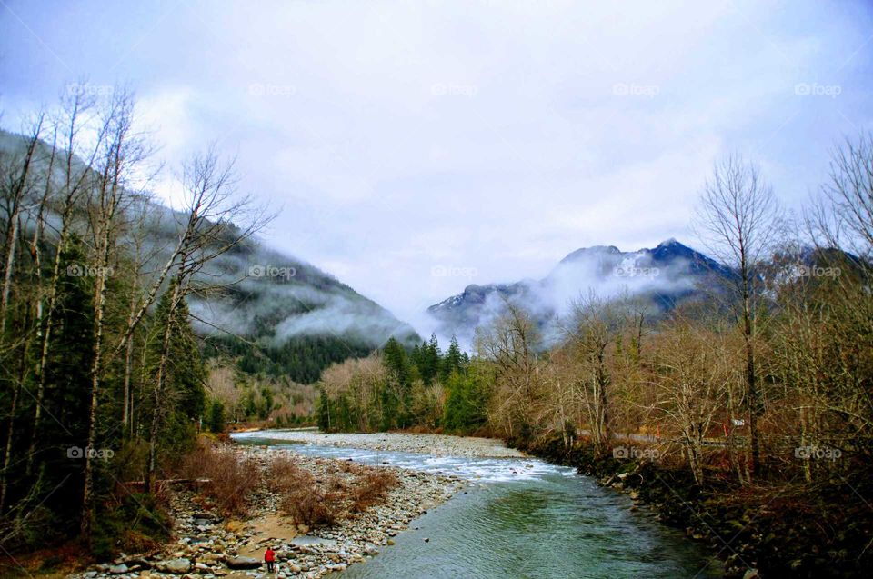 beautiful river with snowcapped mountains and fog