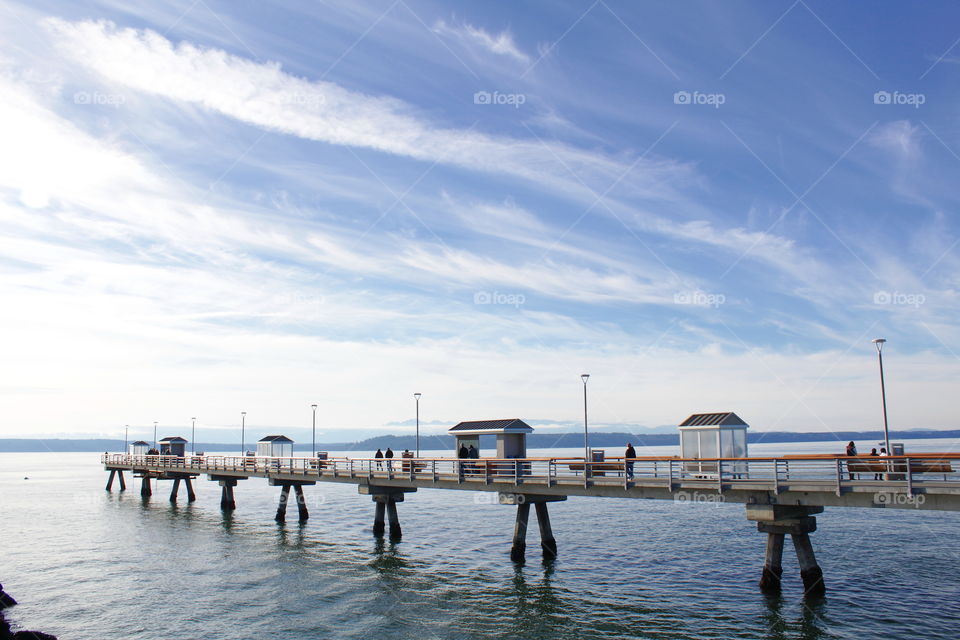 Ocean pier on a clear day with mountain backdrop