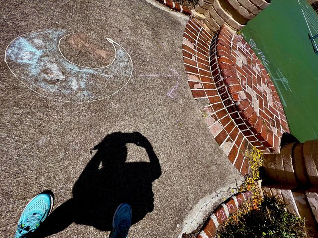 Photo of the shadow of a photographer using iPhone to take a picture of street images such as graffiti and strong visual patterns