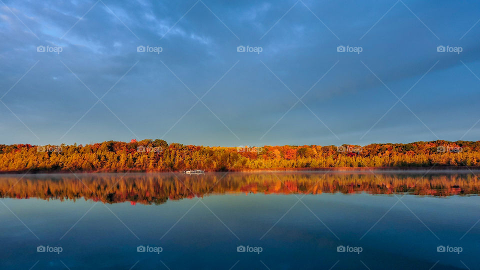 Beautifully colored autumn trees reflecting on the lake in Wisconsin
