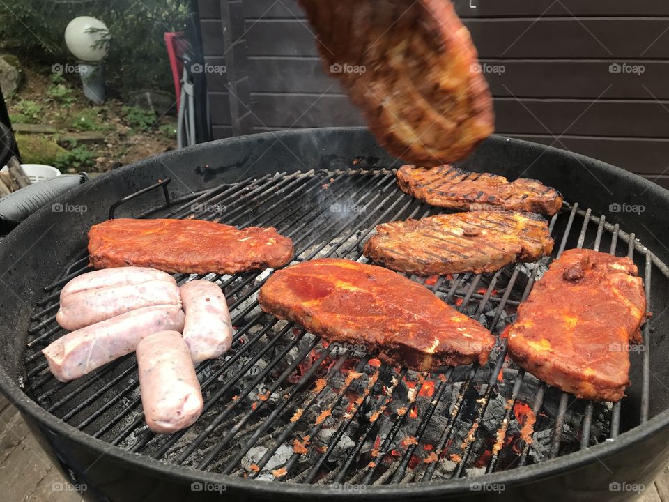 Barbecue meat on a kettle grill