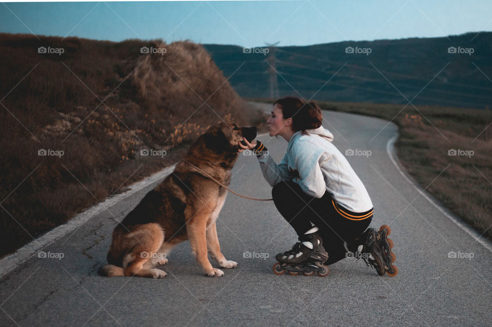 Girl kisses her dog after skating.