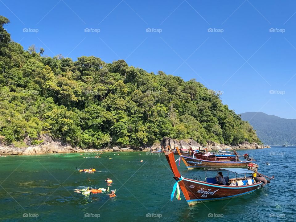 Diving tourists and long tailed boats 