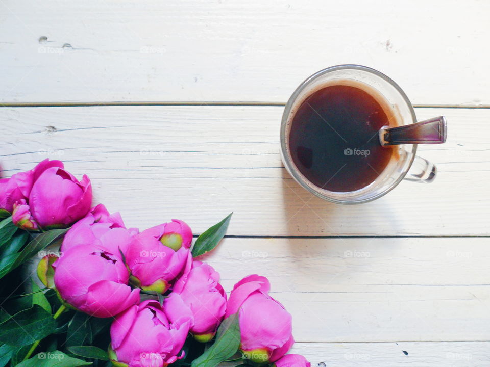 pink peony flowers and cup of coffee on a white background