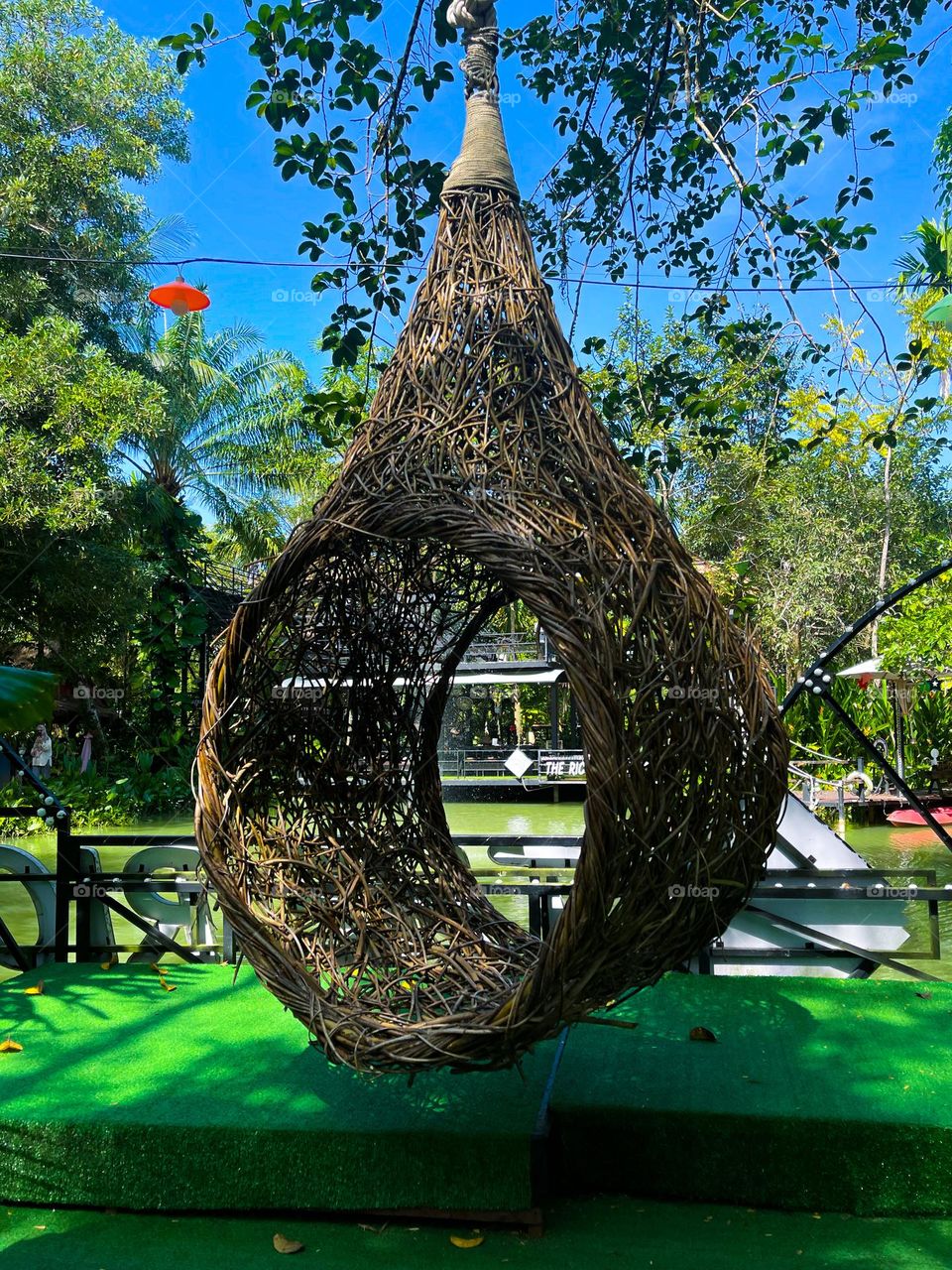 A nest swing made from twigs and rattan hanged on a platform 