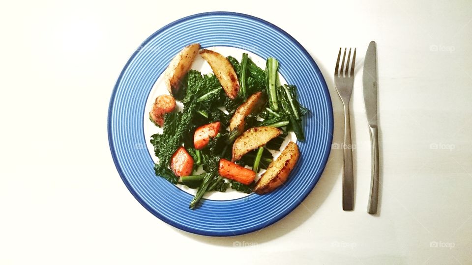 Plate of food with baked carrots and potatoes