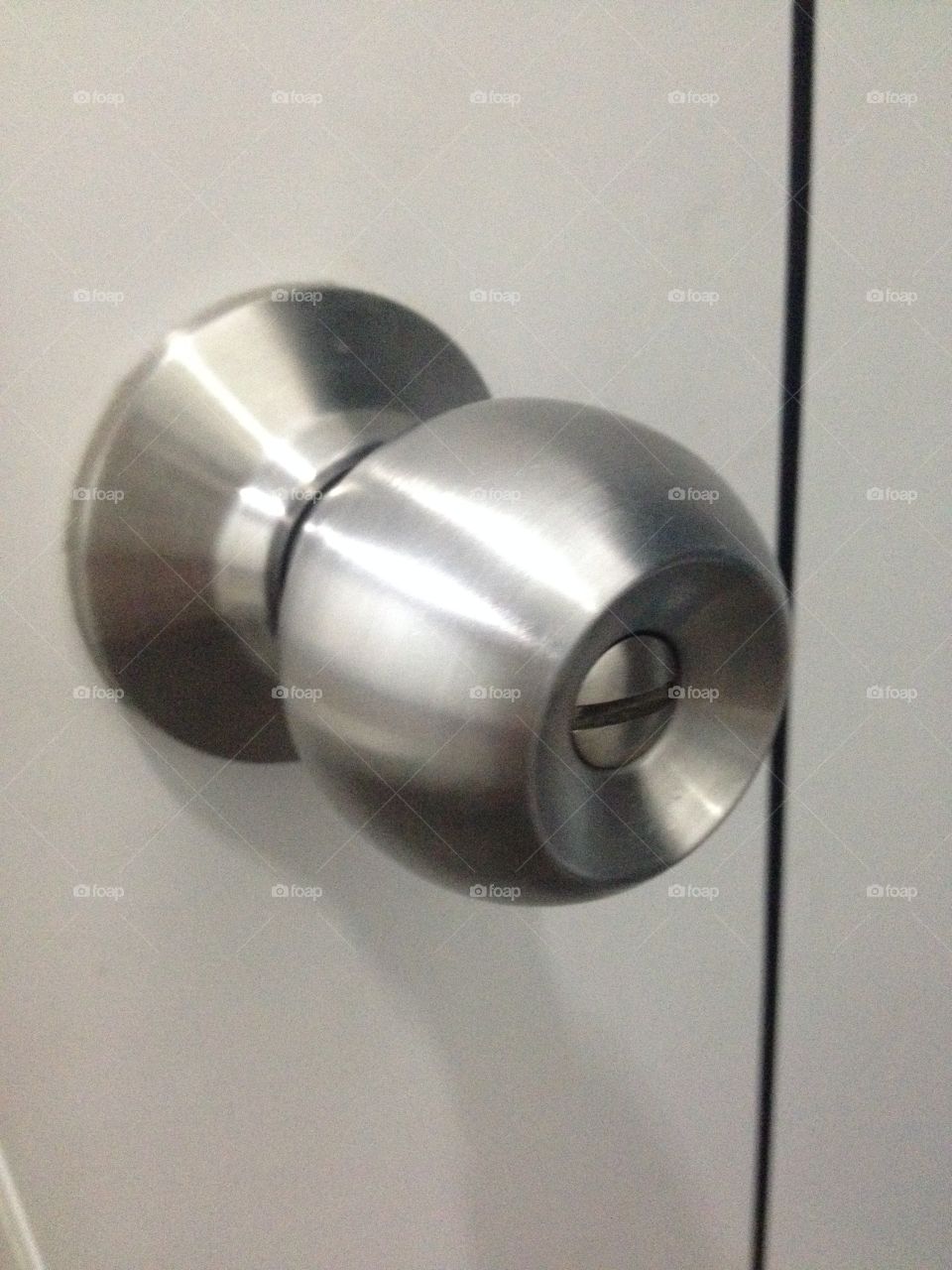 Stainless steel knob and white bath room door.