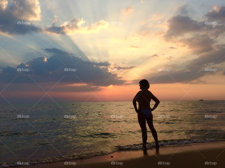 Silhouette female person enjoying sunset at sea