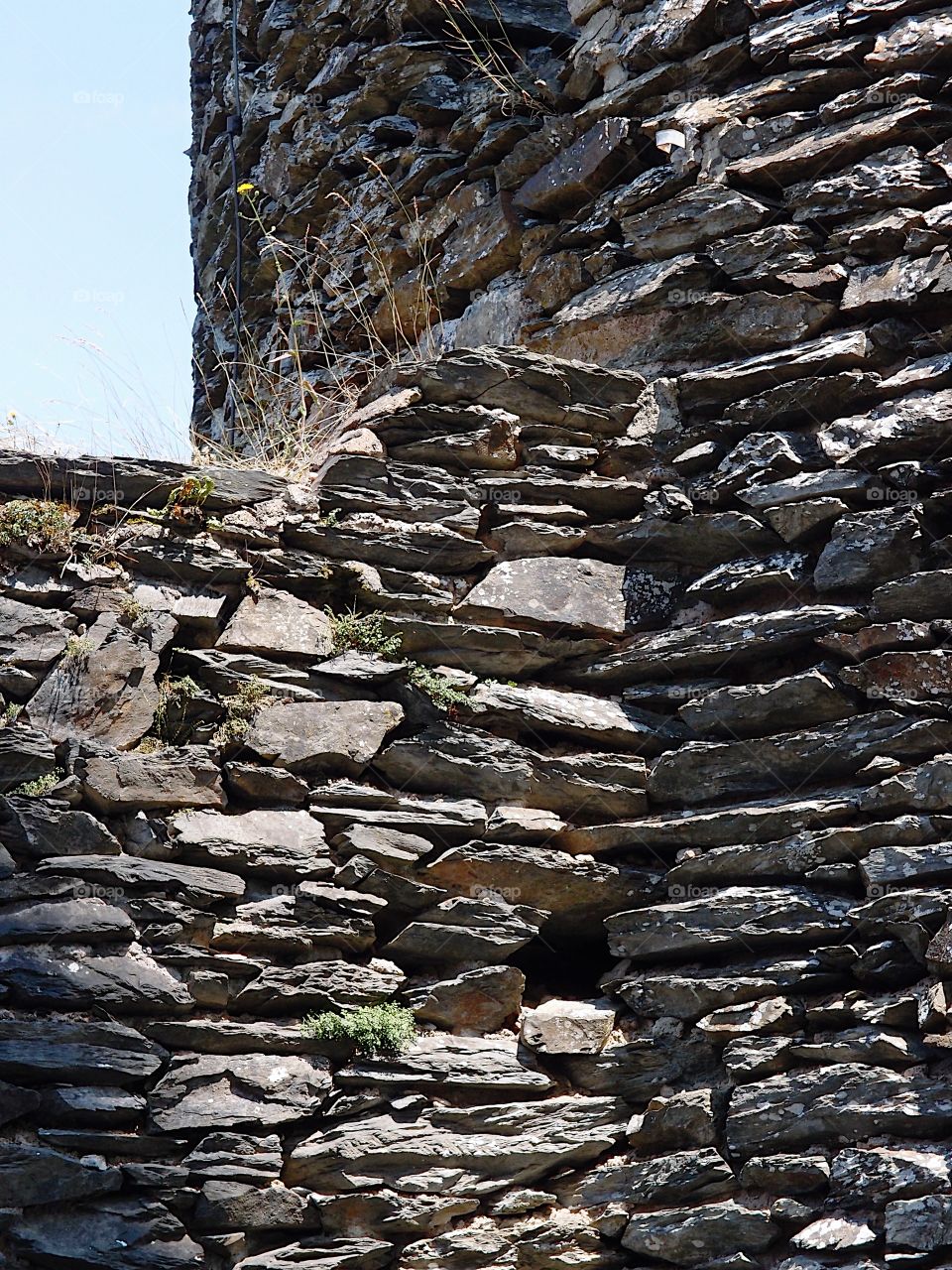 The detailed stone exterior wall of an old part of Chateau dé Vianden in Vianden Luxembourg on a sunny summer day. 