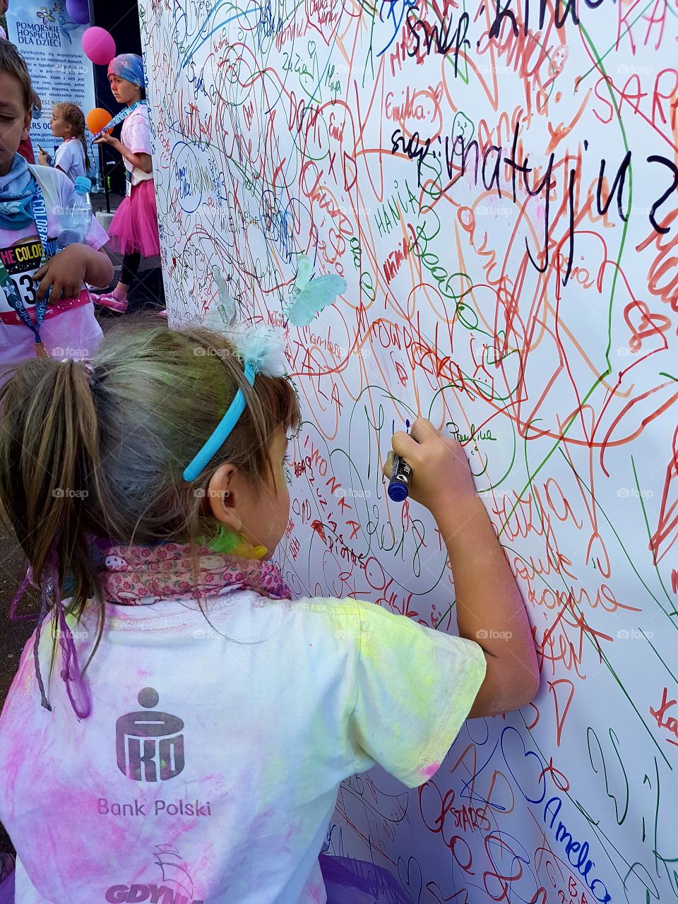 girl writing on the wall in the color run