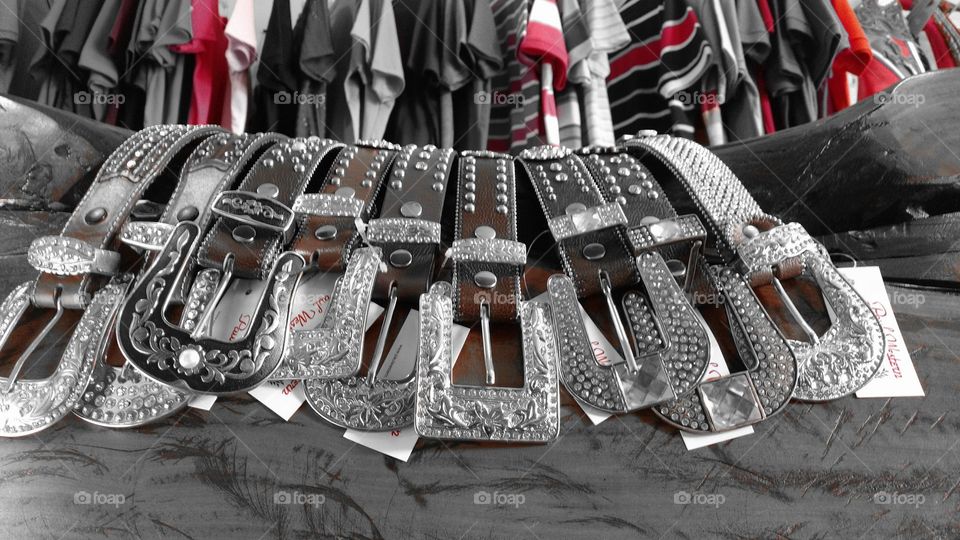 Tecidos e couros. Roupas e cintos country em loja.