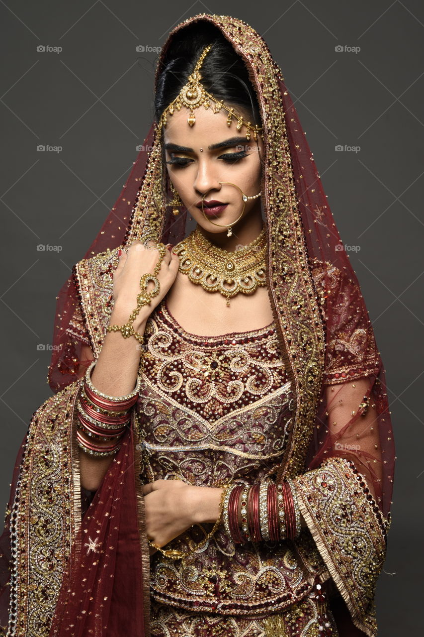 Beautiful indian bride on grey background