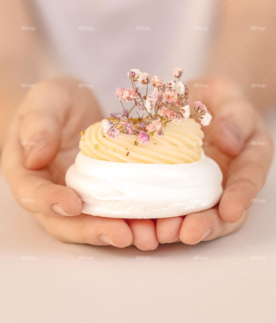 hands holding pavlova cake