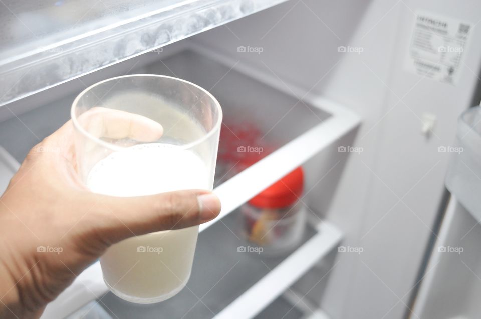 Hand holding a glass of milk