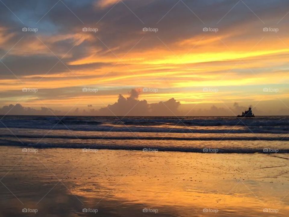 Golden dawn. Ship on the horizon. Morning sky. Florida dawn. Beach before sunrise 