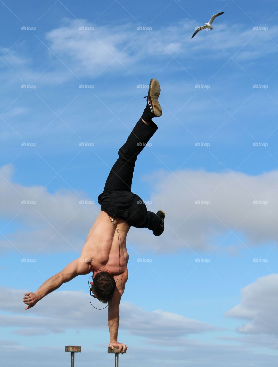 Man doing handstand against sky