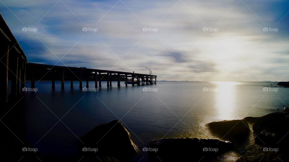 Wooden bridge at Rayong beach and beautiful sunlight with cloud 