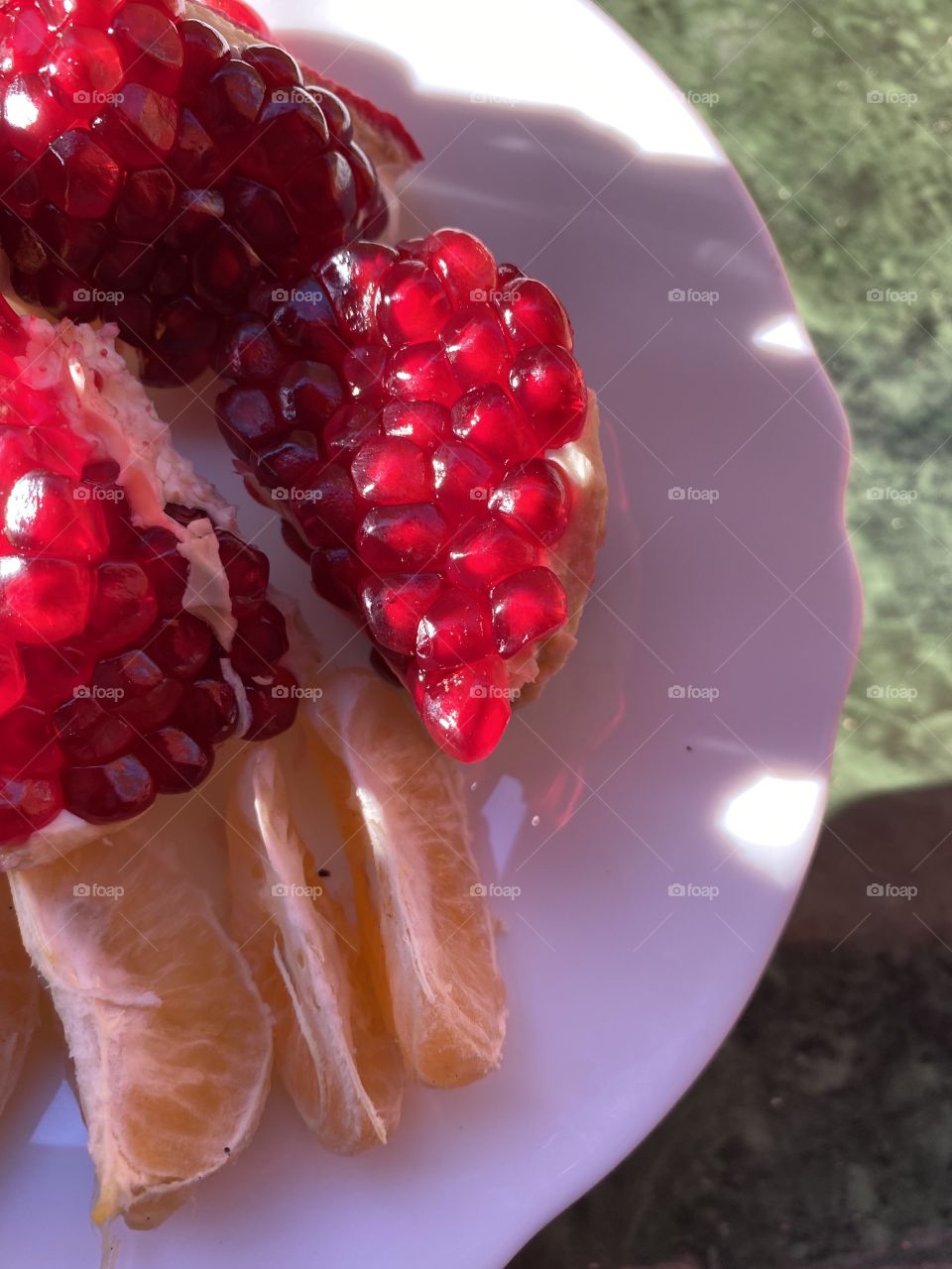 Pomegranate and other fruit on a white plate