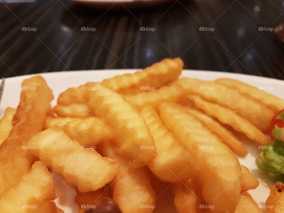 Close up of crispy French fries on plate ready to eat