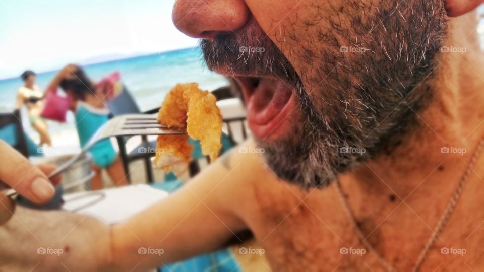 Eating delicious fried squid by the beach in Athens,Greece