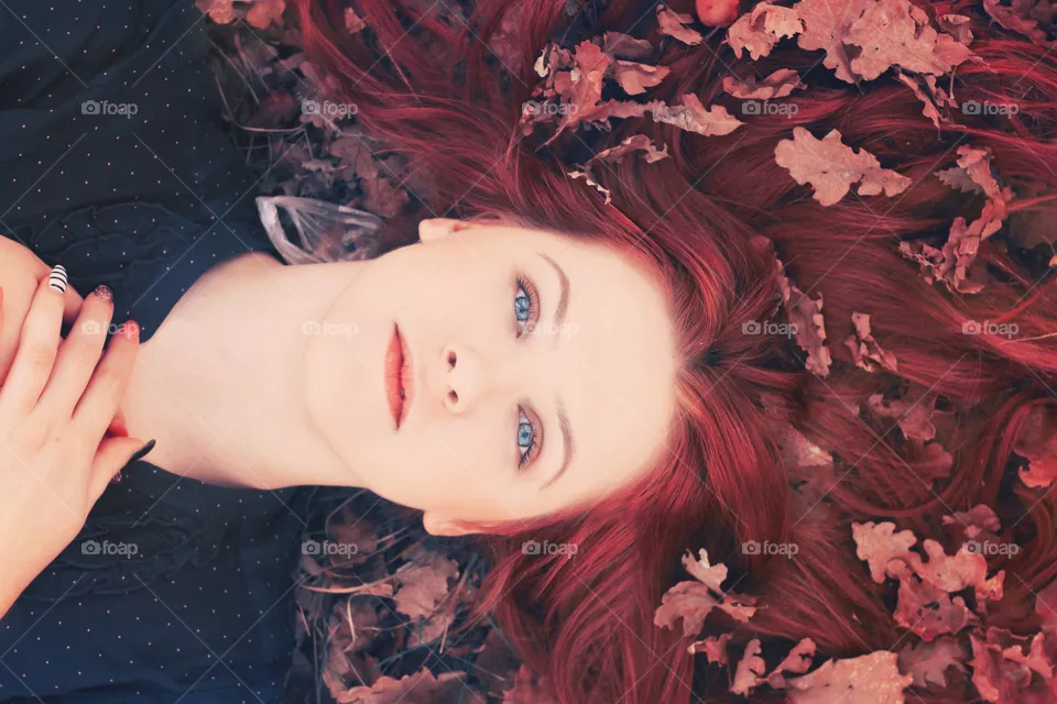 Close-up of a woman lying on dry leaves