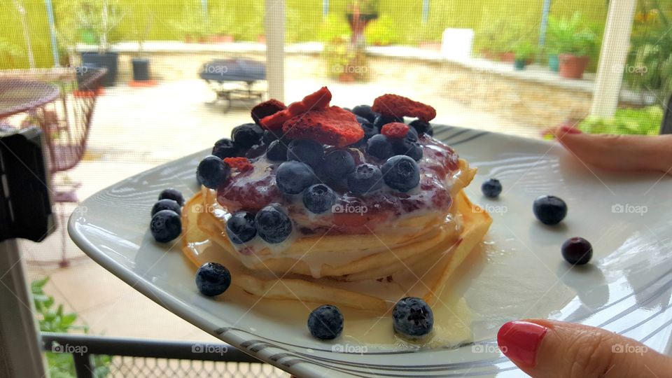 Pancakes with blueberries and strawberries for breakfast