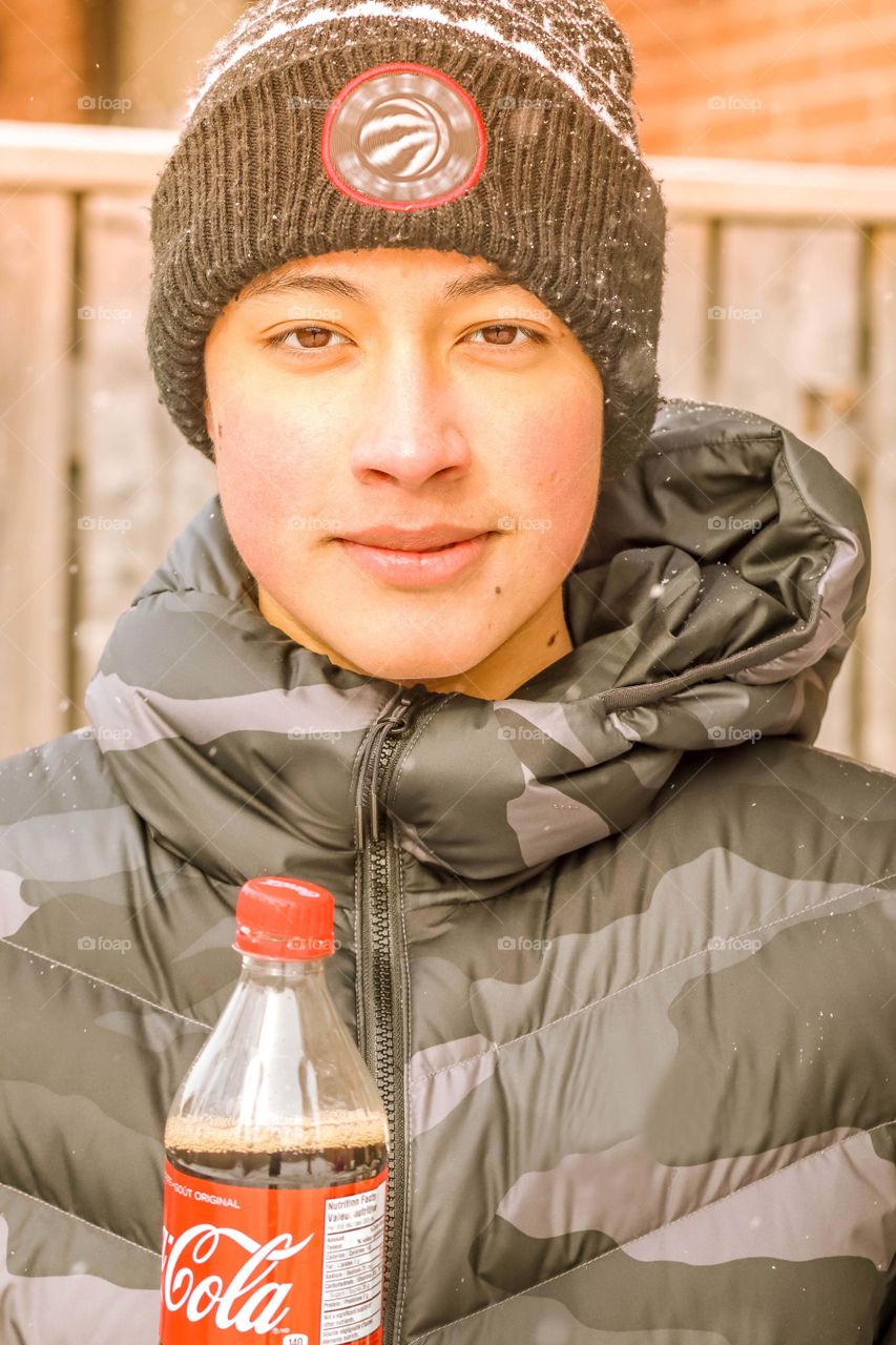 Happy teenager with a bottle of coca cola