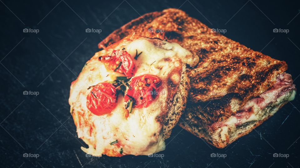 Macro shot of a pomodorini and basil small pizza and ham and cheese focaccia