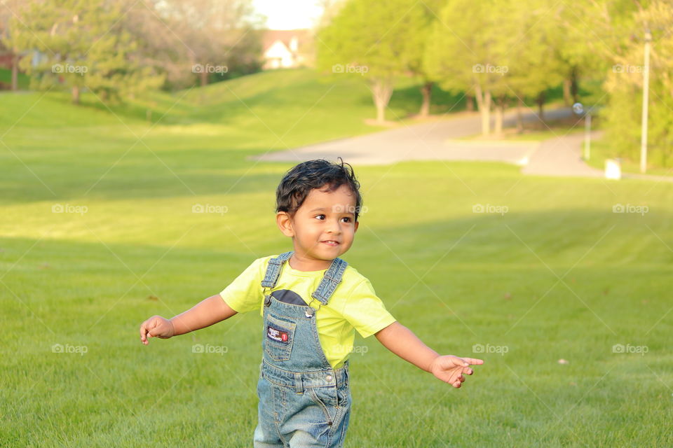 Toddler playing in grass field happily