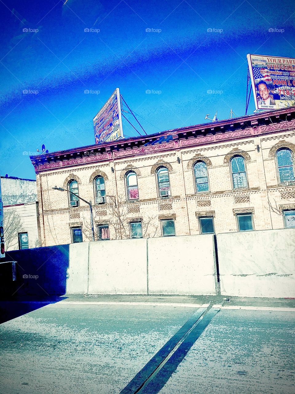 This old style New York City building with arched ornamented windows was photographed on a bright sunny summertime afternoon in 2020 from a moving car on route from Forest Green, Bklyn to our destination in LIC, Queens, NY. Hypnotic Productions
