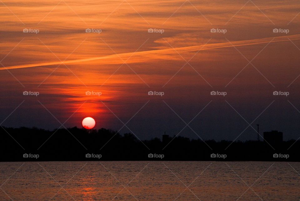 Sunset over lake with silhouetted trees