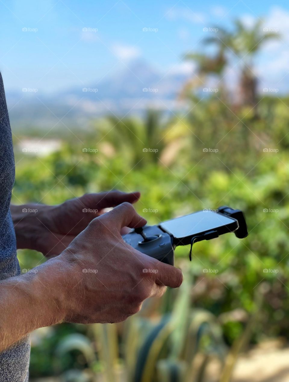 Drone pilot using a controller to fly his drone