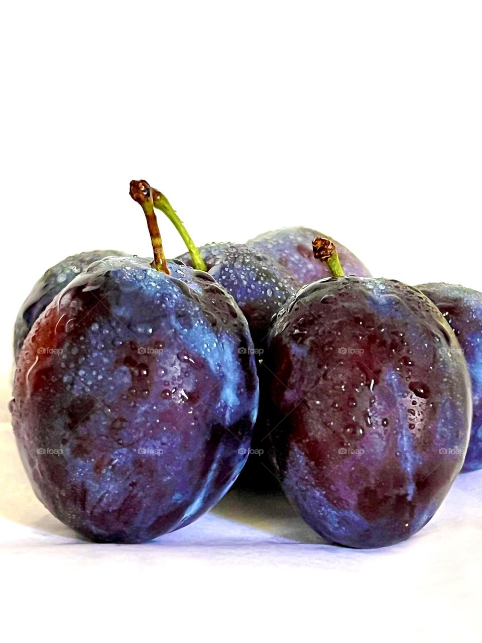 Plums are photographed close-up on a white background