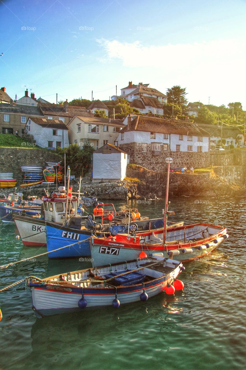 Sunset Over. Fishing Village. A busy harbour full of fishing boats with a Cornish village behind and sunset.