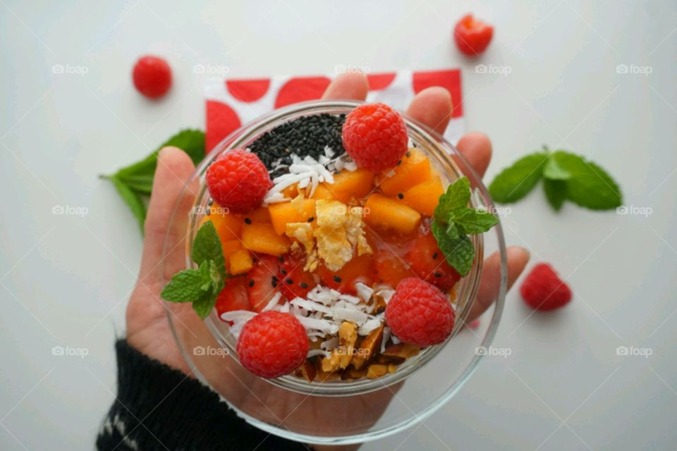 Smoothie fresh fruits bowl - peach, raspberry,  almonds,  strawberries,  coconut,  honey,  seeds and mints