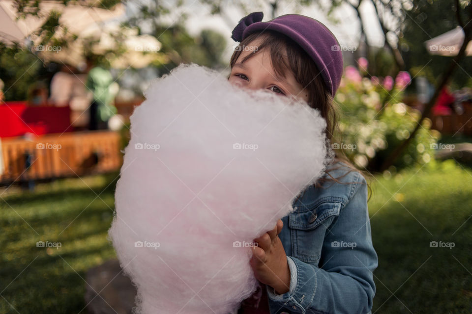 Little girl eating sugar outdoor