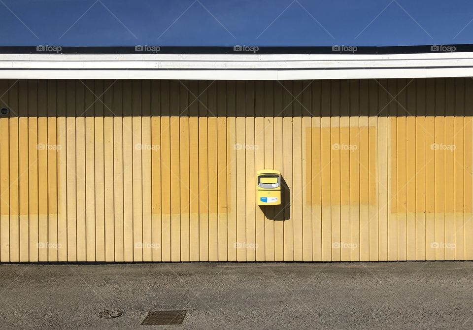 Yellow mailbox on yelllow wall