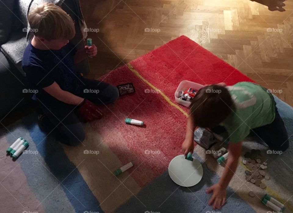 Two boys counting money on red carpet