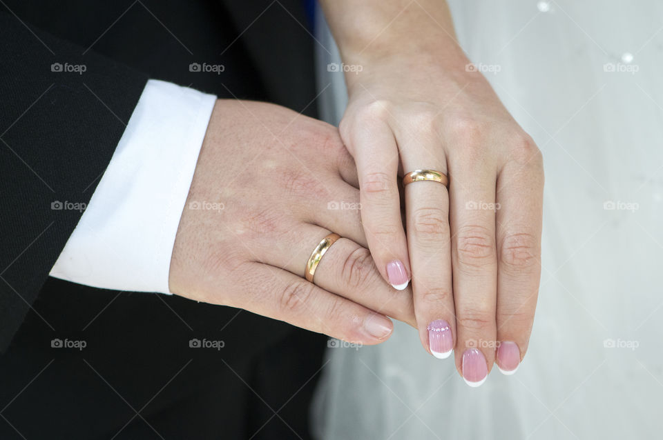 Young couple just married showing their rings with overlapping palms