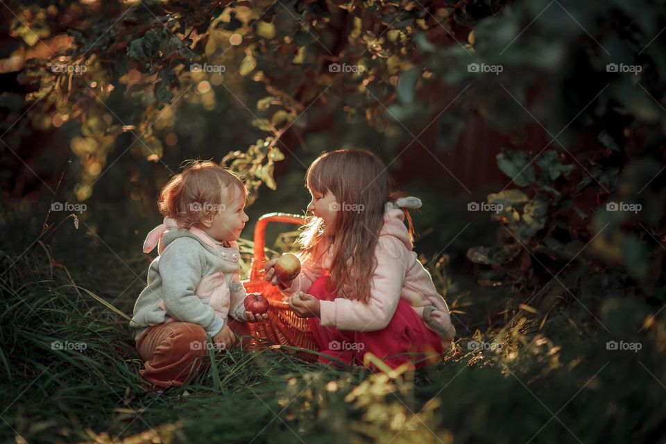 Little sisters portrait with apple