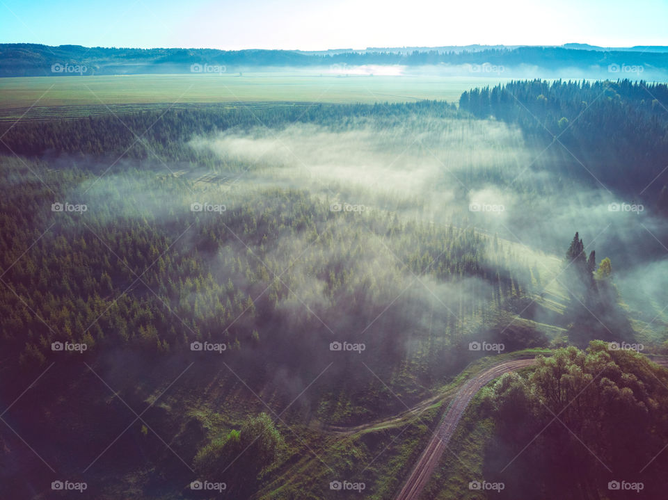 Aerial view of countryside landscape with field and fog
