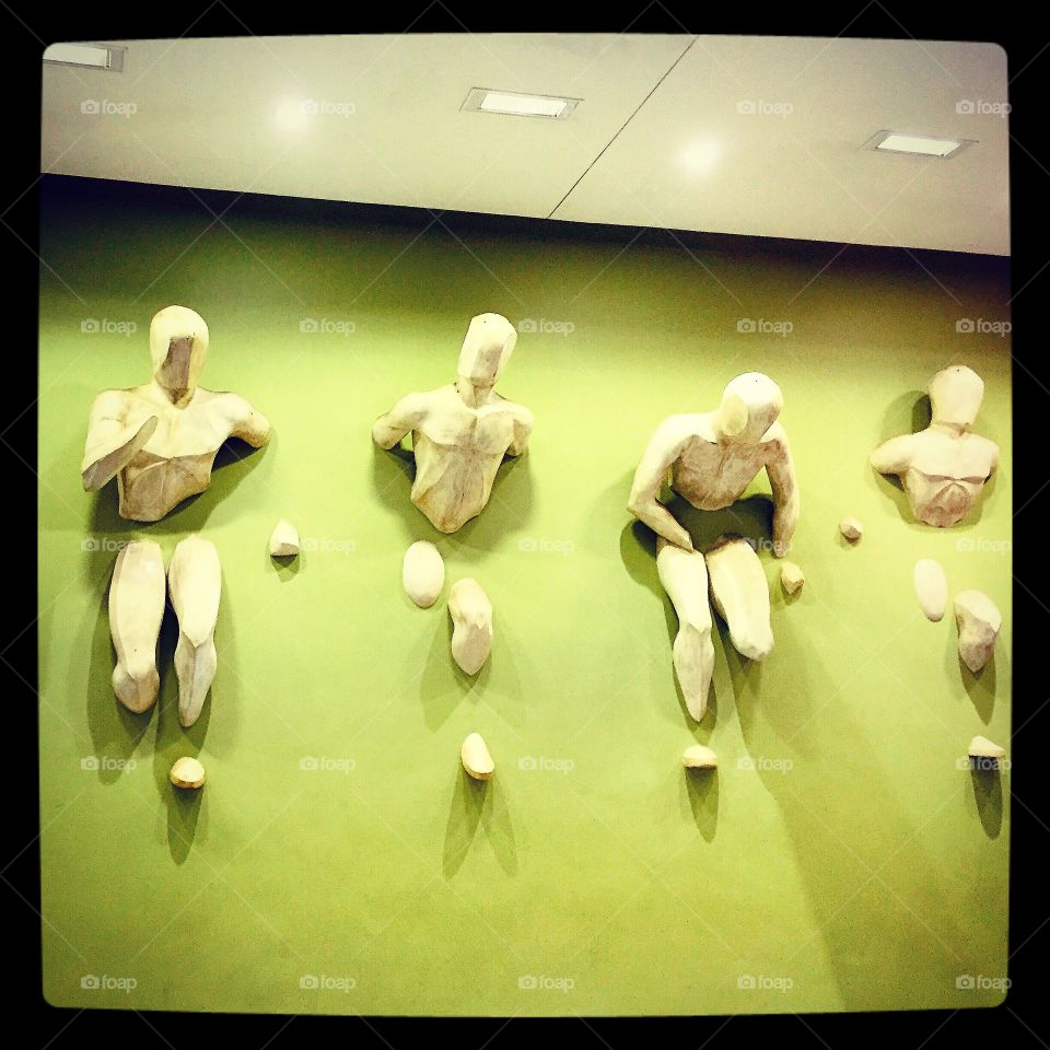 Running Wall. Sculptures of athletes on a green wall
