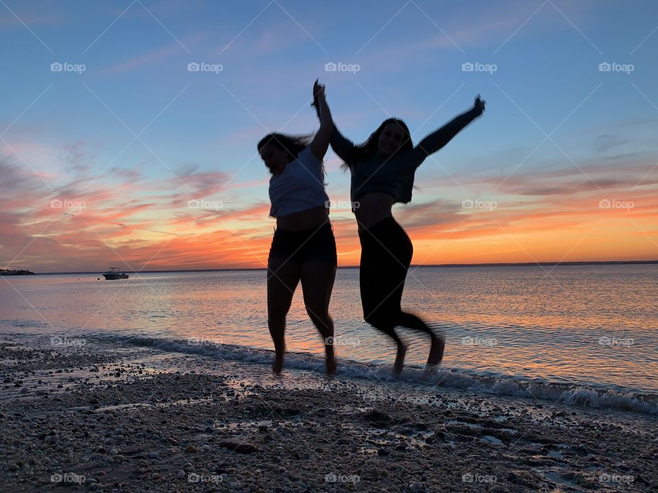 Jumping for joy in the sunset. Summer fun in the sun. 