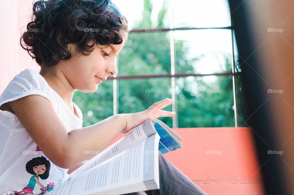 My girl studying near window.