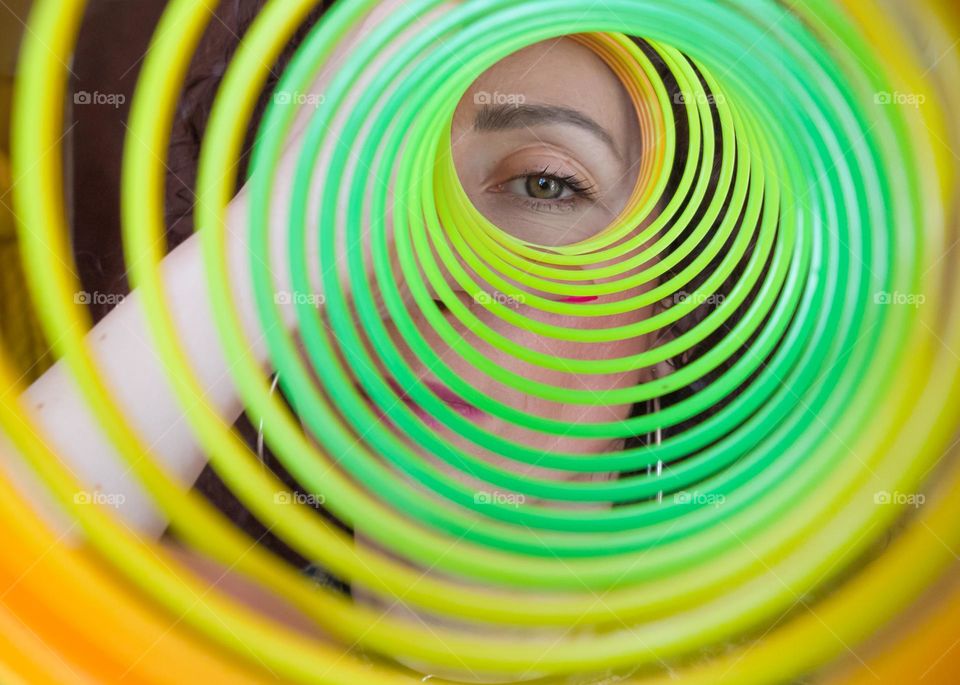 Circle, A Woman Looks through Rainbow Spring Toy