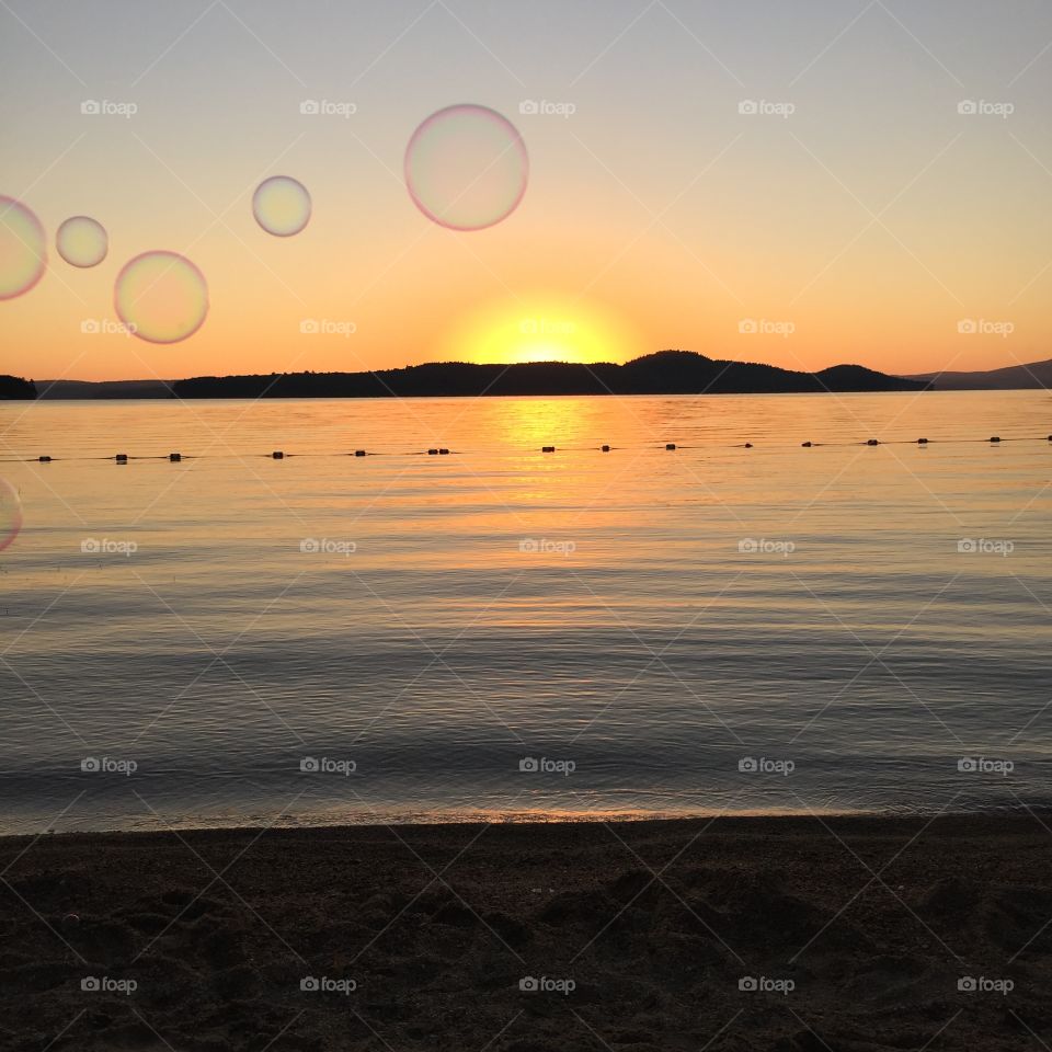 Blowing bubbles at sunset on Lake Winnipesaukee, New Hampshire 