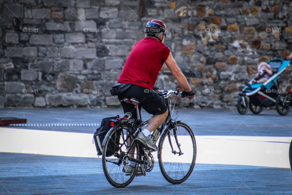 Older fit man is riding a bicycle on a street