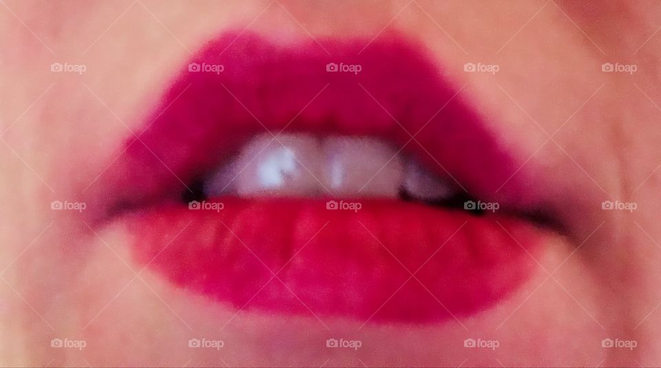 Closeup portrait of lips with near red lipstick.