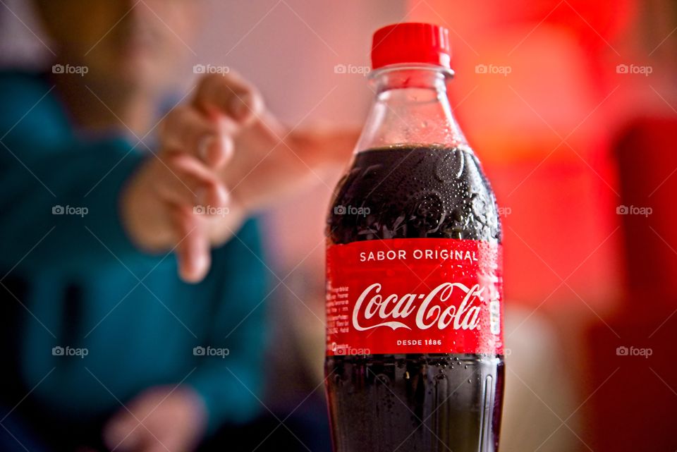 Man taking a bottle of Coca Cola in the living room